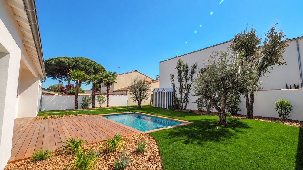 Jardin aménagé avec piscine, terrasse en bois, oliviers et palmiers